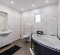 Fürdőszoba a villában káddal, függesztett WC-vel és modern csempékkel.