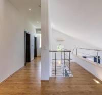 A villa belső tere fehér falakkal, fa dekorációjú padlóval és korláttal.