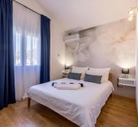 Hálószoba a villában nagy virágokkal a falon és fa dekorációjú padlóval.