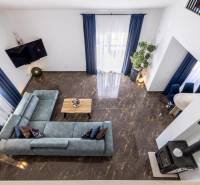 Villa kilátással a nappalira, kék kanapéval és márványpadlóval.