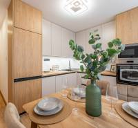 Konyha egy kétszobás lakásban, étkezőasztallal és fa dekorációjú padlóval.