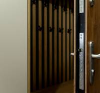 Kilátás a nyitott bejárati ajtóra és a fogasfalra fa dekor padlóval.