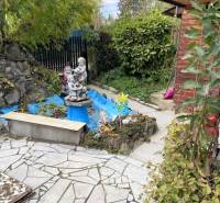 A kassai Vyšné Opátske városrészben található hétvégi ház kertje téglaházzal és szoborral.