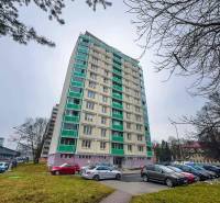 Magas lakóépület a Banská Bystrica SNP sugárútján parkolóval az előtérben.