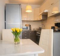 Konyha egy kétszobás lakásban fehér étkezőasztallal és sárga tulipánokkal.