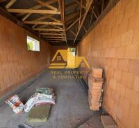 Családi ház építése Nové Zámky utcájában téglafalakkal és gerendás mennyezettel.