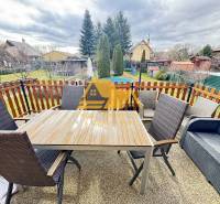 Az újvári ház teraszán van egy asztal székekkel és kanapéval.