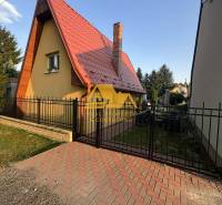 Ház az utcán Érsekújváron, hegyes tetővel és téglakéménnyel.