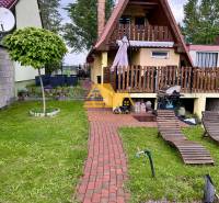 Házikó piros tetővel, terasszal és pihenőkerttel Érsekújváron.