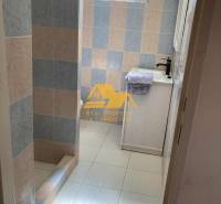 Fürdőszoba a házikóban színes csempékkel és zuhanyzóval, zuhanyfallal.