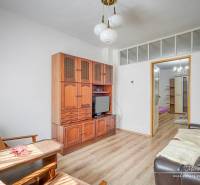 Nappali egy családi házban fa bútorokkal és kényelmes ülőhelyekkel.