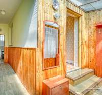 Fa belső tér folyosóval és bejárattal egy családi házban, világos falakkal.