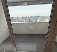 Kilátás egy egyszobás lakás erkélyéről Trebišovban, Hodvábna, nagy erkélyajtókon keresztül.