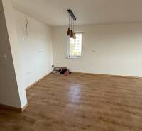 Két hálószobás lakás szobája fa dekor padlóval és függő lámpákkal.