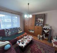 Nappali egy családi házban dekoratív szőnyeggel és kanapéval.