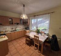 Konyha családi házban fa dekorral és étkezőasztallal.