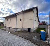 Családi ház Zbehyben mellékúttal, gyepfelülettel és kék szemetes edénnyel.