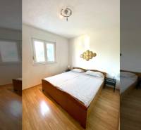 Hálószoba családi házban, franciaággyal és fa dekorációjú padlóval.