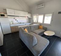 Konyha sarokkanapéval és étkezőasztallal, családi ház, sötét burkolatú padló.