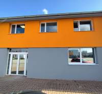 Az épület a Nyitrai Štúrova utcán, világos homlokzatú üzlethelyiségek.