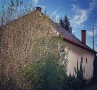 Családi ház Felsőkelebányán, sűrű növényzettel és sűrű fákkal körülvéve.