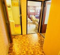 Folyosó egy kétszobás lakásban fa mintázatú padlóval és szobákba nyíló ajtókkal.