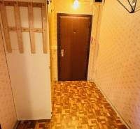 Folyosó fa hatású padlóval és világos tapétával egy kétszobás lakásban.