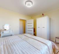 Hálószoba ággyal, szekrénnyel és fésülködőasztallal egy családi házban.