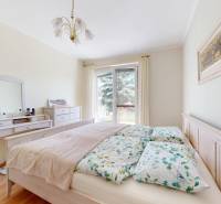 Hálószoba családi házban ággyal, fésülködőasztallal és fa mintázatú padlóval.