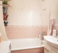 Fürdőszoba káddal, mosdóval és tárolóhellyel egy háromszobás lakásban.