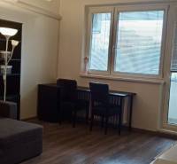 Nappali egy kétszobás lakásban sarokkanapéval és fa dekorációjú padlóval.