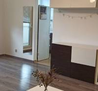 Nappali egy kétszobás lakásban, fa dekor padlóval és erkéllyel.