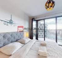 Hálószoba egy 2 szobás lakásban erkéllyel és repülőgép dekorációval a falon.