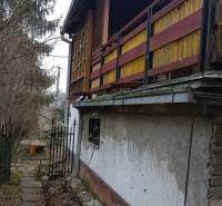 Chata na Výtockej ulici v Moravanoch nad Váhom s dreveným balkónom obklopená prírodou.