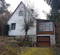 Chata na Výtockej ulici v Moravanoch nad Váhom, obklopená hustým lesným porastom.