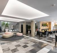 Irodák fekete-fehér padlóval, oszlopokkal, ülőhelyekkel és kávézóval a belső térben.