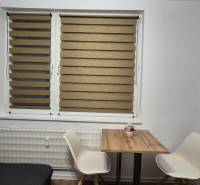 Étkező sarok faasztallal és két fehér székkel egy egyszobás lakásban.