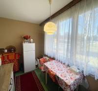 Konyha a háromszobás lakásban étkezőasztallal és nagy ablakkal.