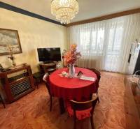 Étkező rész egy háromszobás lakásban piros terítővel és nagy ablakokkal.