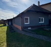 Családi ház Mýtne Ludanban, kerttel körülvéve, kék égbolttal és nappal.