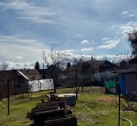 Kert nyírt gyep és faanyag a családi ház területén Mýtné Ludanyban.