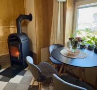 Kandalló a családi ház nappalijában kerek asztallal és két székkel.