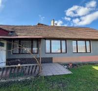 Családi ház Mýtné Ludanyban udvarral, terasszal és szürke homlokzattal.