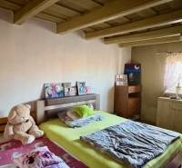 Hálószoba családi házban fa mennyezettel, ággyal és plüssmackóval.