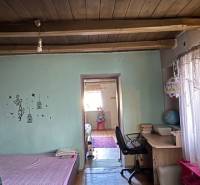 Szoba fa dekoros padlóval, ággyal, íróasztallal és dekoratív gerendákkal a mennyezeten.