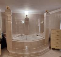 Fürdőszoba családi házban sarokkáddal és díszített bútorokkal.