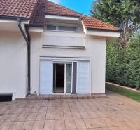 Családi ház Komáromban terasszal, kerttel és fehér spalettákkal.