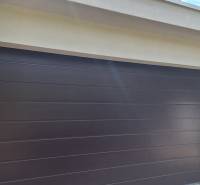 Családi ház garázsajtaja Komáromban, zölddel körülvéve.