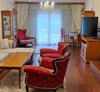 Nappali egy családi házban piros székekkel és fa mintázatú padlóval.