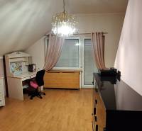 Szoba fa dekorációjú padlóval, bútorokkal és csillárral egy családi házban.